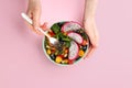 Woman with delicious exotic fruit salad on pink background, top view Royalty Free Stock Photo