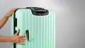 A woman demonstrates a broken suitcase on a white background. Damaged baggage during the flight.