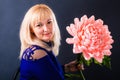 Woman demonstrates huge pink flower hand made of paper