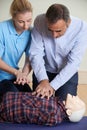 Woman Demonstrating CPR On Training Dummy In First Aid Class Royalty Free Stock Photo