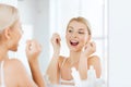 Woman with dental floss cleaning teeth at bathroom Royalty Free Stock Photo