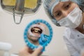 Woman dentist doing teeth checkup man patient in a dental chair at medical clinic. Royalty Free Stock Photo