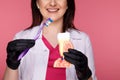 Woman dentist with gloves showing on a jaw model how to clean the teeth with tooth brush properly and Royalty Free Stock Photo