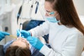 Woman dentist performs a hygienic procedure for a young patient