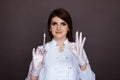 Woman dentist showing ok sign and holding syringe with anaesthesia isolated.