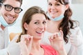 Woman at dentist using dental floss