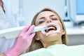 Woman dentist using dental intraoral scanner while examining patient teeth