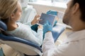 Woman with dentist watching tablet