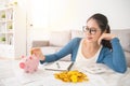 Woman deposit gold coin into piggy bank