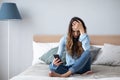 Woman in depression sitting at home on the couch with a mobile phone in her hands. Portrait of an upset girl Royalty Free Stock Photo