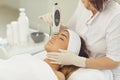 Woman dermatologist making ultrasound apparatus facial cleaning for young woman Royalty Free Stock Photo