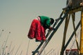 Woman descending a ladder, Uros island, Titicaca Lake, Peru