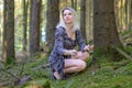 Woman in designer tatters crouching in a forest Royalty Free Stock Photo