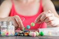 Woman designing colorful necklace with plactic beads