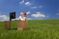 Woman At Desk Using Megaphone In Green Field Royalty Free Stock Photo