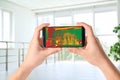 Woman detecting heat loss in room using thermal viewer on smartphone