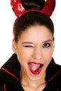 Woman in devil costume blinks eye.