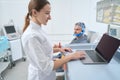 Woman diagnostician at the workplace conducts EEG - electroencephalography