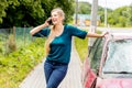 Woman dialing her phone after car crash Royalty Free Stock Photo