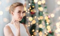 Woman with diamond jewelry over christmas lights