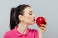 Woman on diet with an apple in the hand against gray background