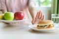 Woman doing cross arms sign to refuse junk food or fast food.