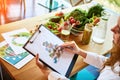 Woman dietitian in medical uniform with tape measure working on a diet plan sitting with different healthy food ingredients in the