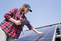 Woman with tablet touching solar panel