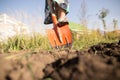 A woman digs a garden with a shovel