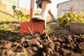 A woman digs a garden with a shovel