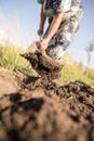 A woman digs a garden with a shovel