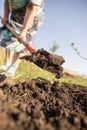 A woman digs a garden with a shovel