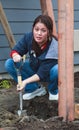 Woman digs post hole for Habitat For Humanity