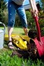 A woman digs soil and soil with a spade shovel and old zinc water can