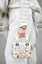 Woman with Dior white leather bag with golden details and Rolex Daytona watch before Frankie