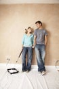 Woman Dipping Paint Roller In Paint While Looking At Man