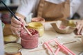 Woman dips a brush into a jar of pink paint Royalty Free Stock Photo