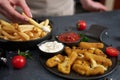 Woman dips french fries into dip sauce with Cheese fried mozzarella sticks on a table Royalty Free Stock Photo