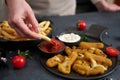 Woman dips french fries into dip sauce with Cheese fried mozzarella sticks on a table Royalty Free Stock Photo