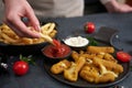 Woman dips french fries into dip sauce with Cheese fried mozzarella sticks on a table Royalty Free Stock Photo