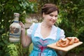 Woman in dirndl dress holding beer and pretzel Royalty Free Stock Photo