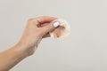Woman with dirty cotton pad after removing makeup on light grey background, closeup