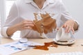 Woman in dirty shirt at wooden desk with coffee spill, closeup Royalty Free Stock Photo