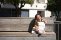 Woman with disability, reduced mobility and small stature sitting on a wooden bench, happy and relaxed sunbathing. Concept