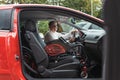 Woman with disability sitting in driver seat, transferring wheelchair inside car