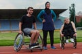 A woman with a disability in a wheelchair talking after training with a woman wearing a hijab and a man in a wheelchair Royalty Free Stock Photo