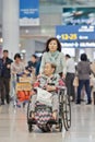 Woman with disabled mother in a wheelchair at Icheon Airport, Seoul, South Korea