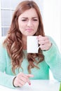 Woman disgusting smell of coffee with face expression