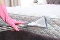 Woman disinfecting mattress with vacuum cleaner, closeup.