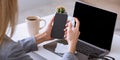 Woman disinfects smartphone and laptop in workplace